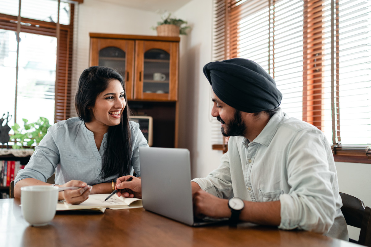 Canva - Cheerful couple discussing business issues at home